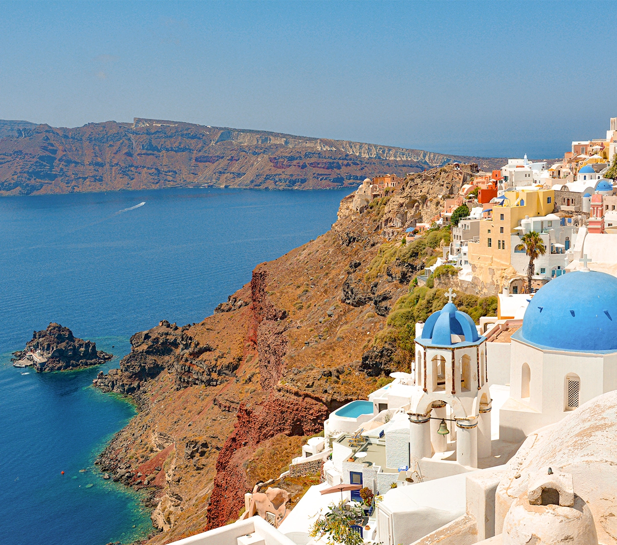 Witte huizen en blauwe koepels aan zee op Santorini